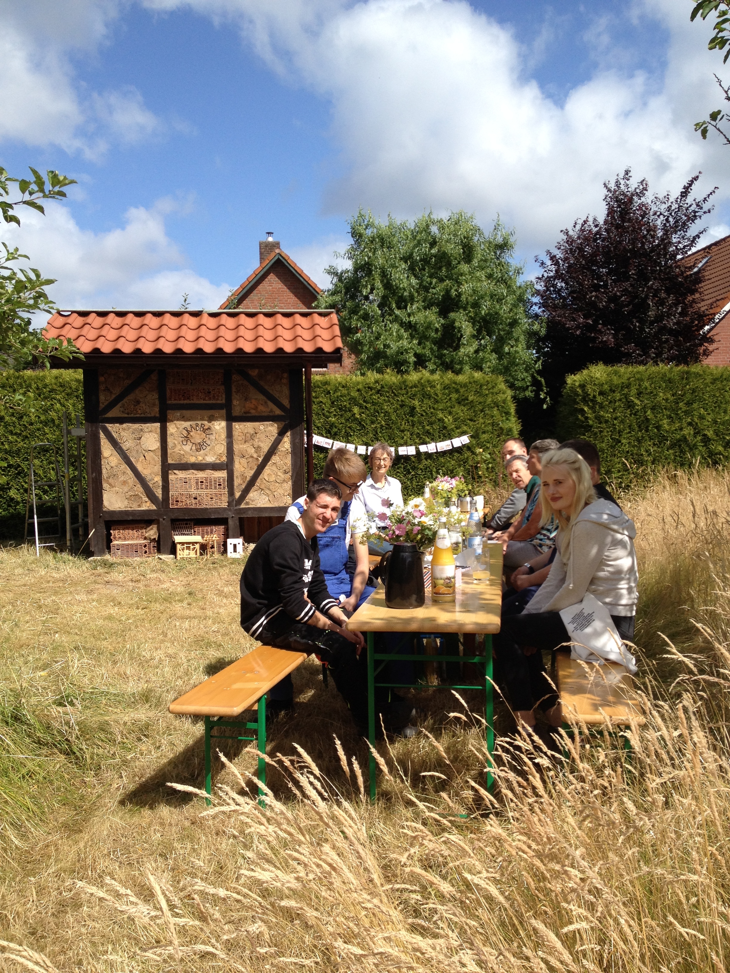Insektenhotel Schiffdorf davor Menschen sitzend auf Bierbänken