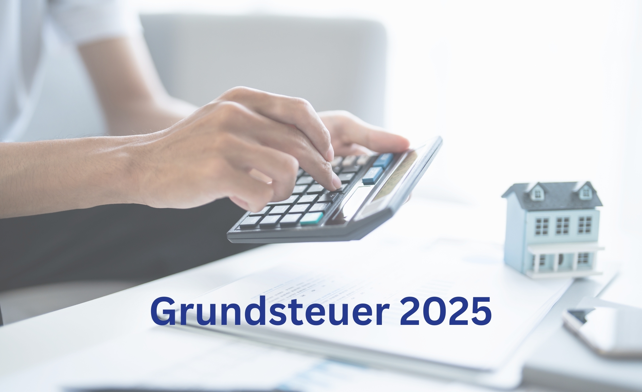 Ein Mann tippt auf einem Taschenrechner, vor ihm auf dem Tisch liegen Dokumente und ein kleines Haus.