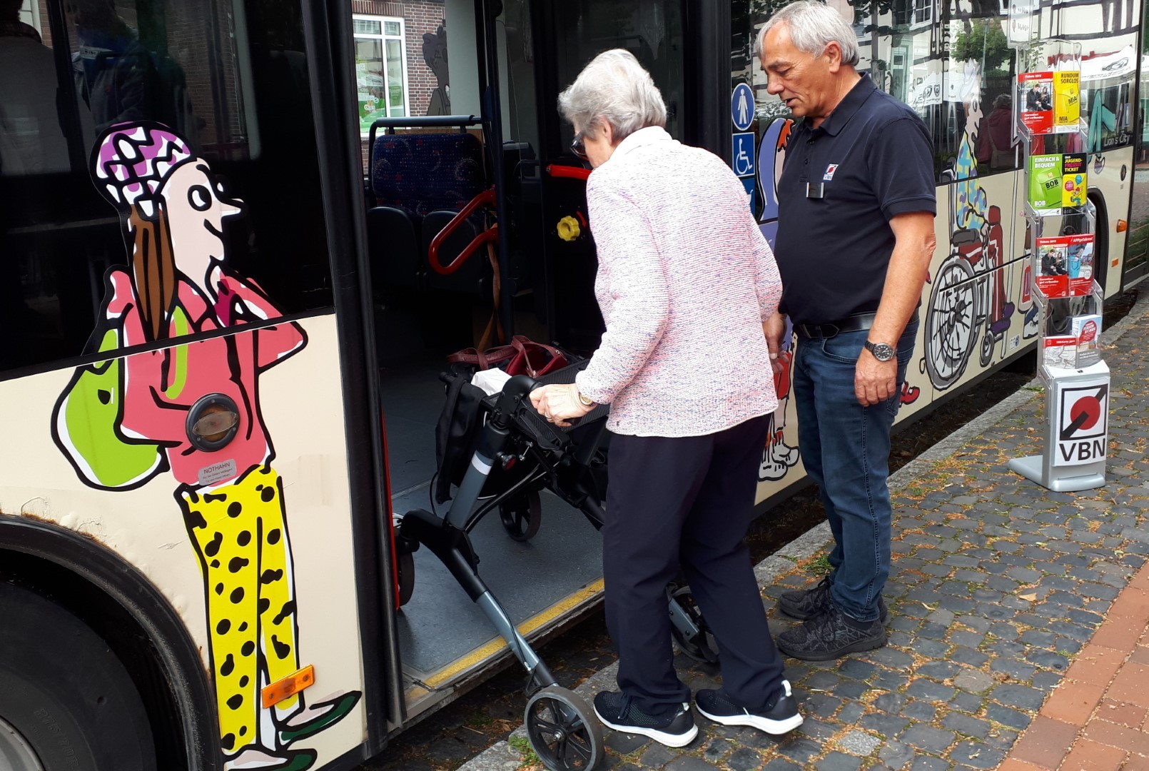 Seniorin steigt mit dem Rollator in einen Bus