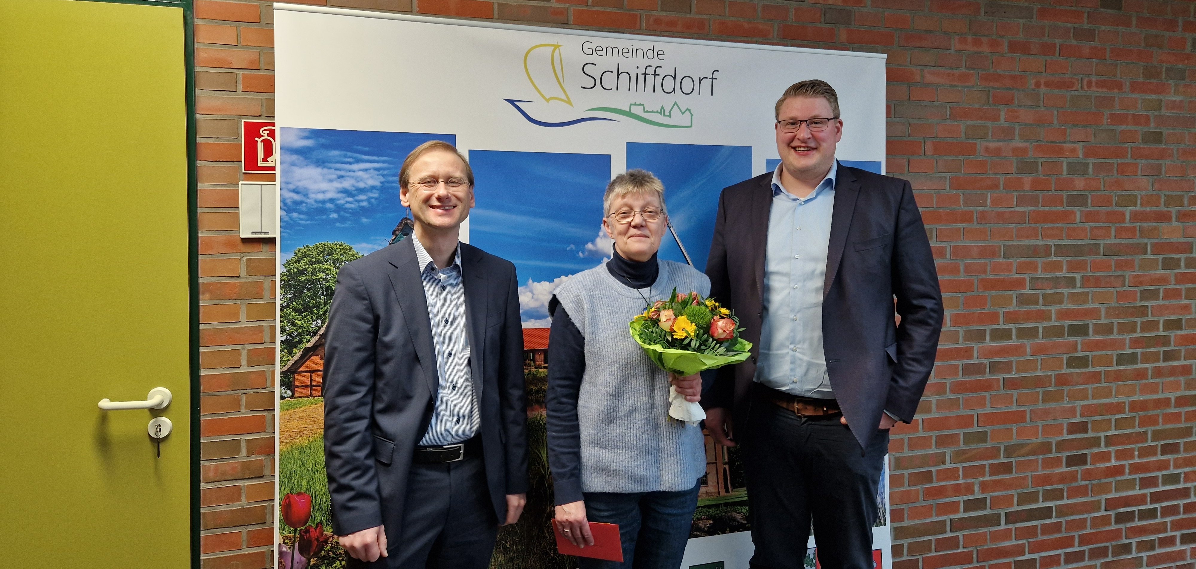 drei Personen vor einem Büro